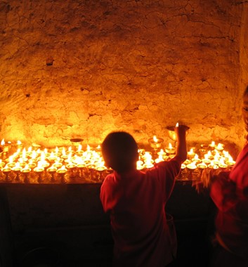 Student buddhist monks light butter lamps in a monastery in Solu Khumbu Nepal