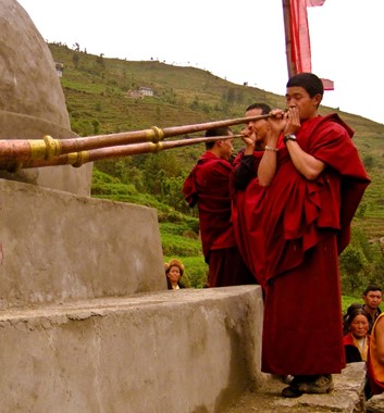 Buddhist monks blow traditional dungchen dharma trumpet horns in Bumburi village Solu Khumbu Nepal